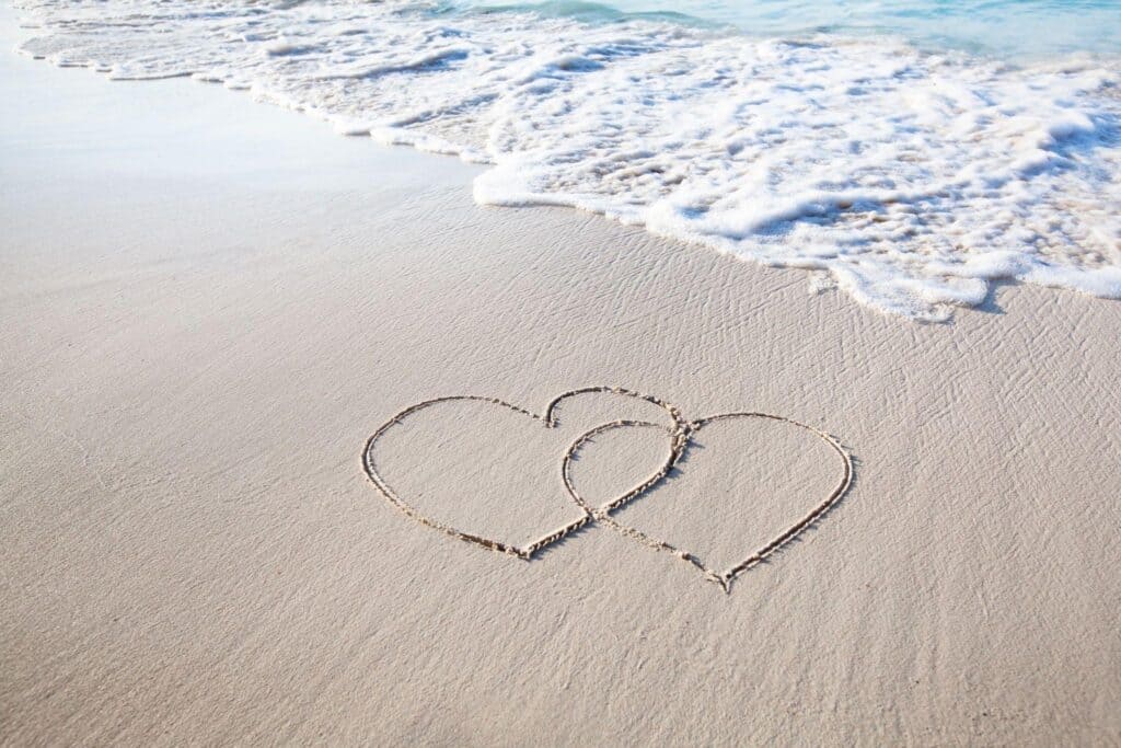 Newlyweds sharing a dip and a kiss at sunset on a Gulf Coast beach