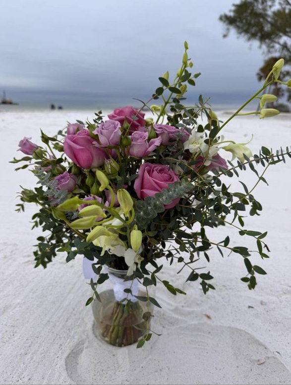 A pink rose bouquet on the white sand at Bradenton Beach