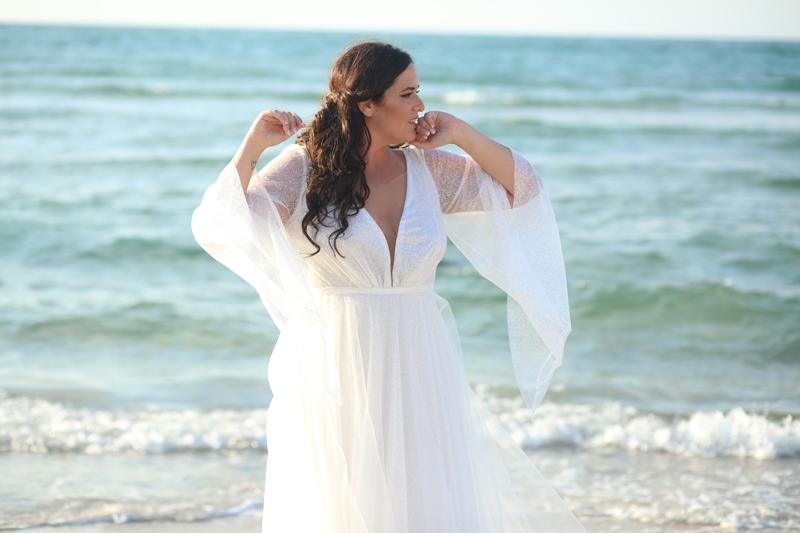 Bride in a flowing white gown at the water's edge on Clearwater Beach