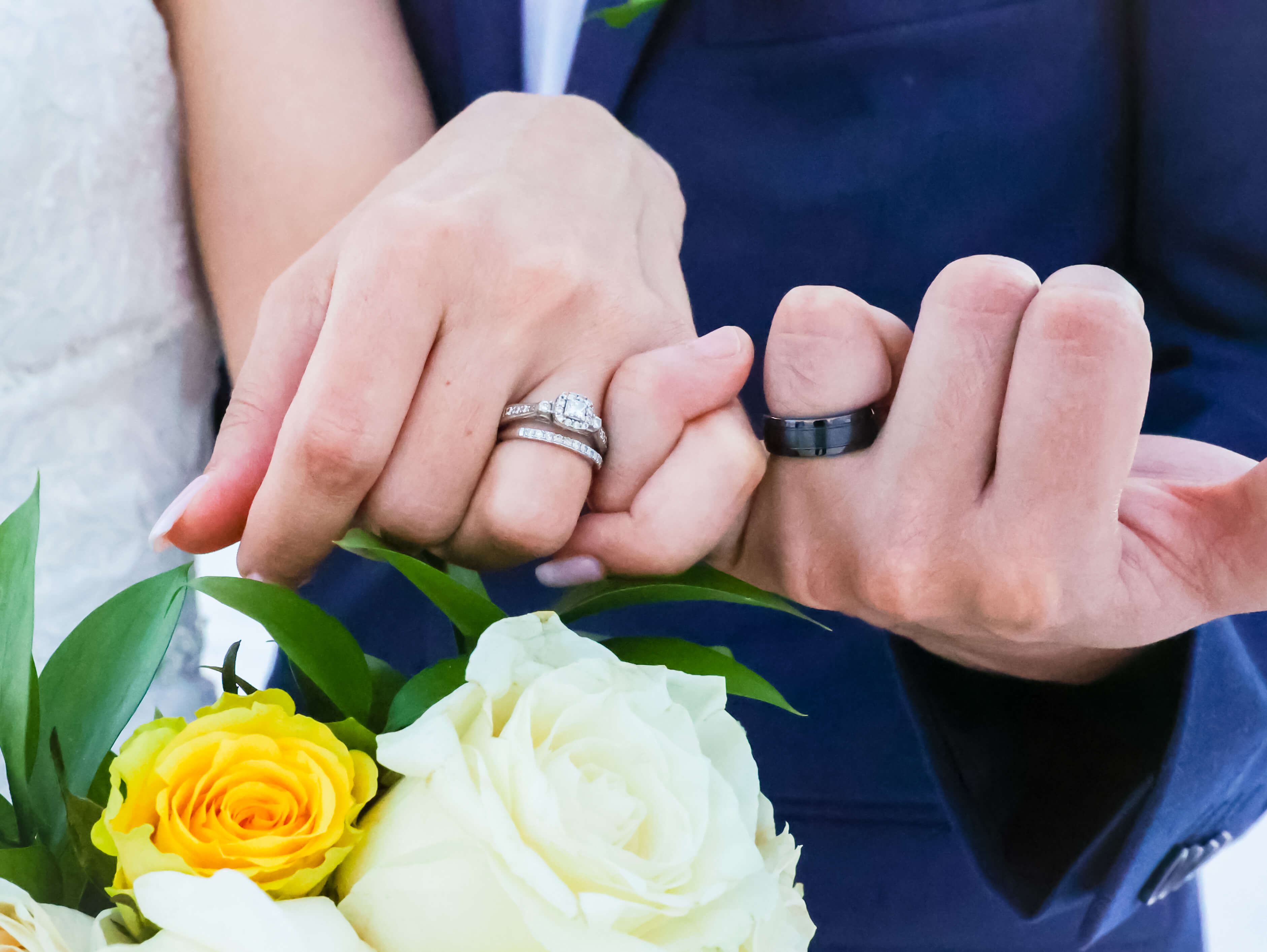 Close-up of the couple's wedding rings and bouquet at Coquina Beach