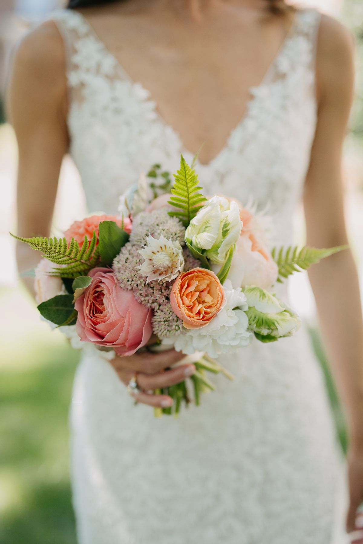 Bride holding a peach garden-rose bouquet on Fort Myers Beach