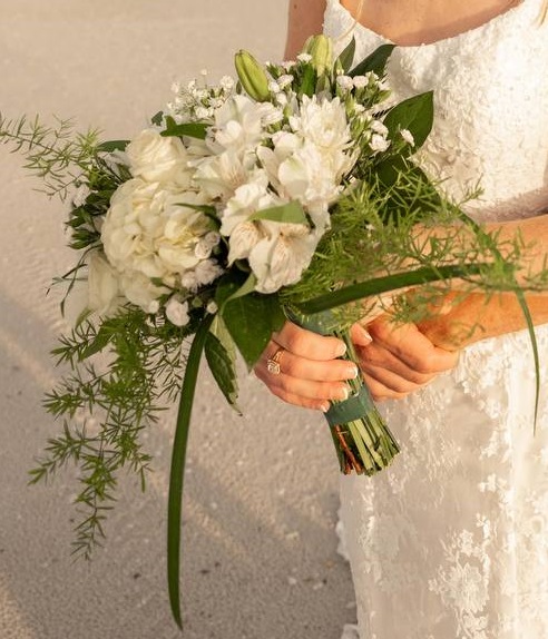 Bride holding a white bouquet on the quiet sand at Nokomis Beach