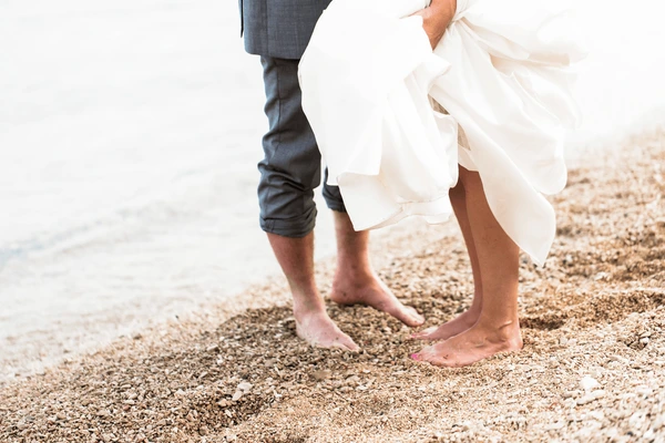 Barefoot couple at the water's edge on the shelly sand of Pass-a-Grille