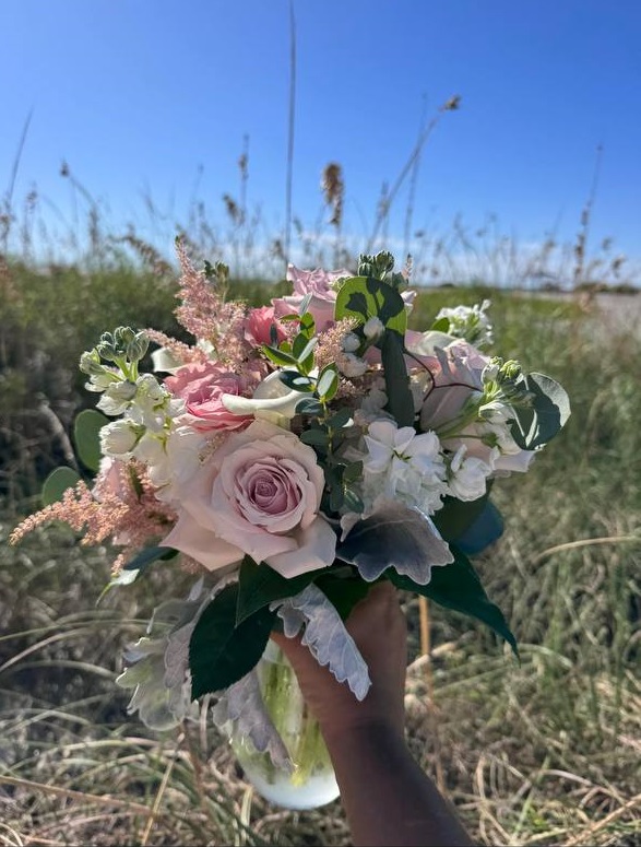 A blush bouquet held against the dune grass at Pass-a-Grille