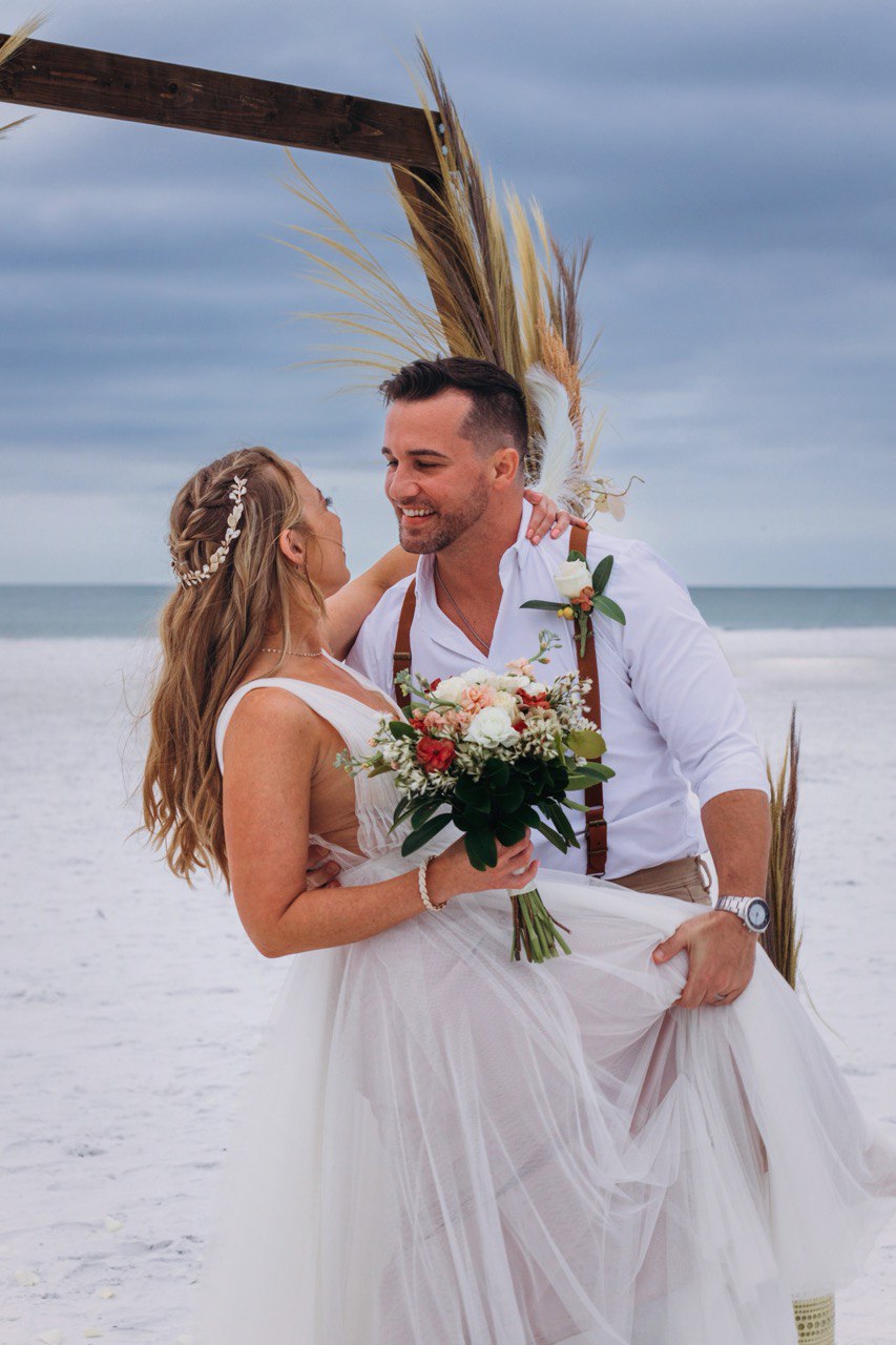 Bride and groom embracing at golden hour by the Gulf on Siesta Key