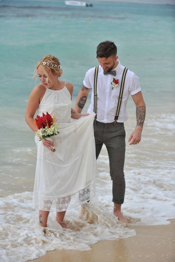 Boho couple standing in the surf with a tropical bouquet on St. Pete Beach