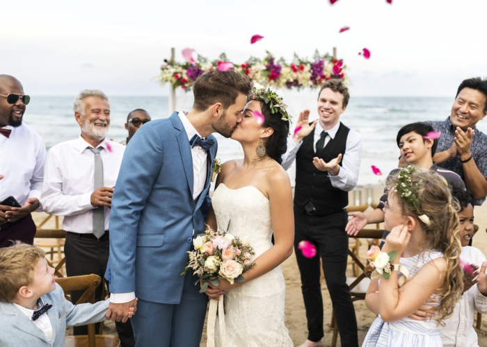 Newlyweds' first kiss in a shower of petals at Turtle Beach