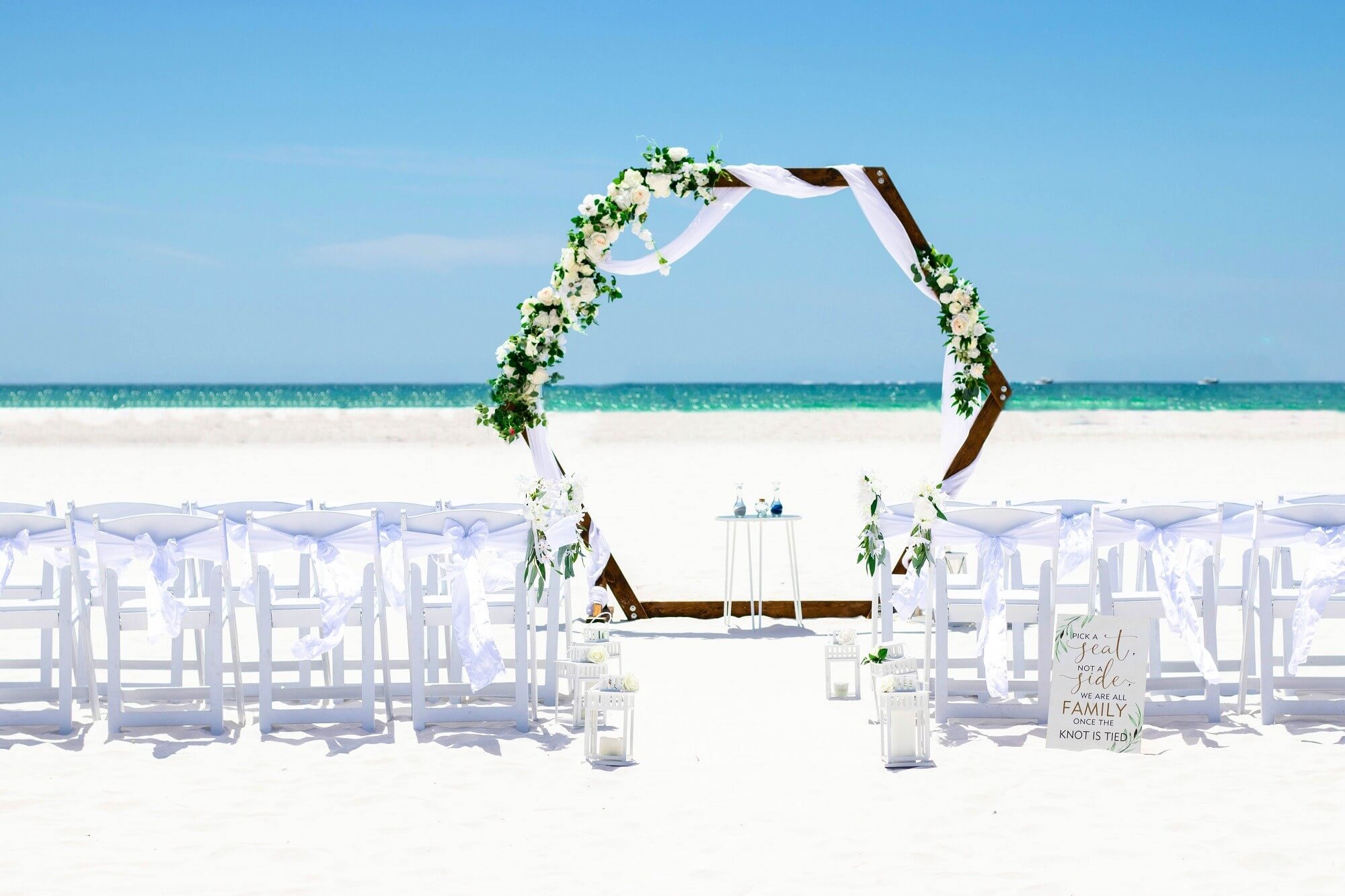Boho triangle beach arch dressed with pampas grass and dried florals among the trees — the Elegant Bliss package