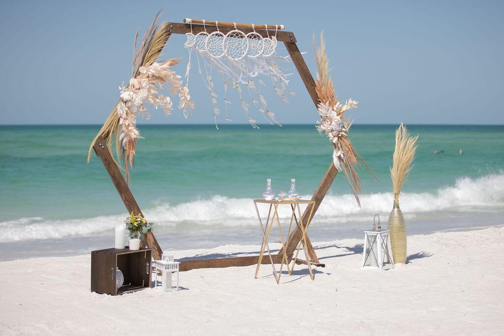 Hexagon boho beach arch with a dreamcatcher and pampas grass at golden sunset — the Magical Bliss package