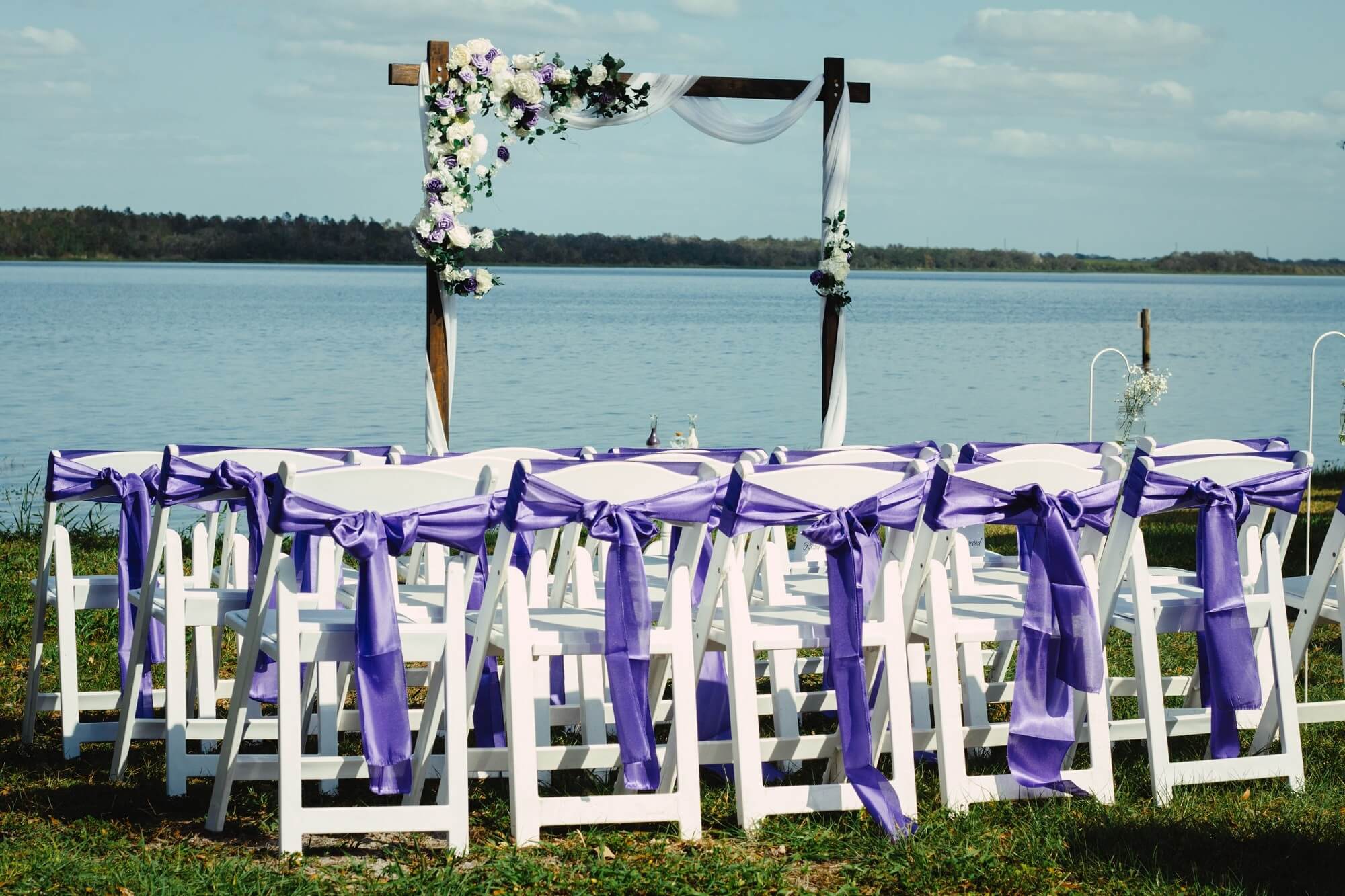 Rustic wooden crates styled with red roses and pillar candles on the grass — the Rustic Glam package