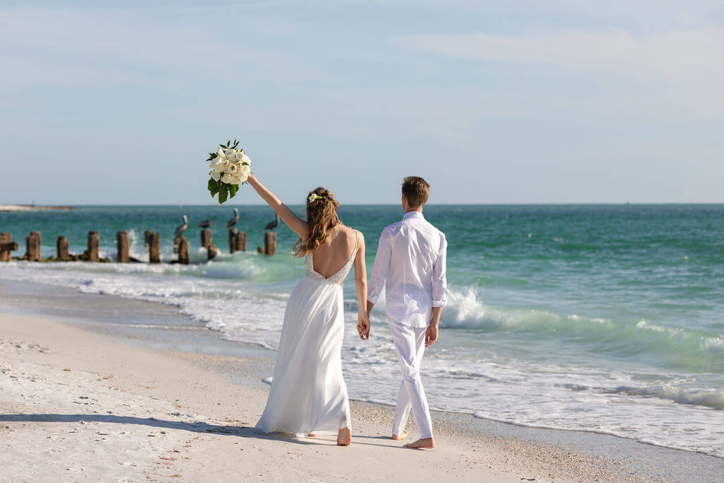 Bride and groom embracing at golden hour on the beach